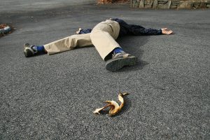 a man who had an accident when he slipped on a banana peel lies on the ground